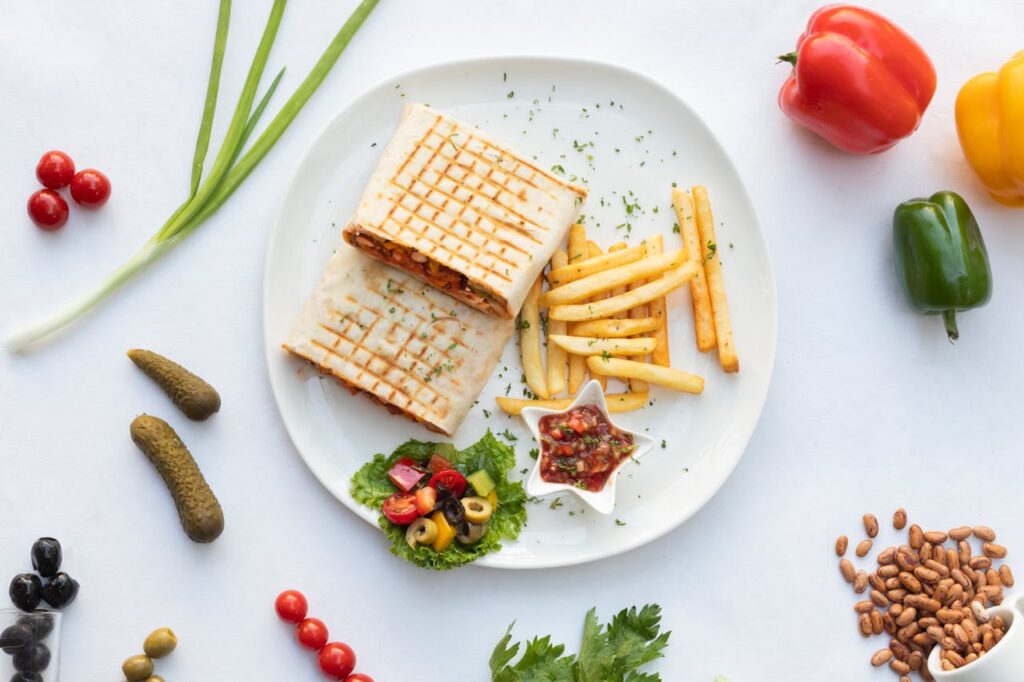 A plate with a sandwich, fries and vegetables